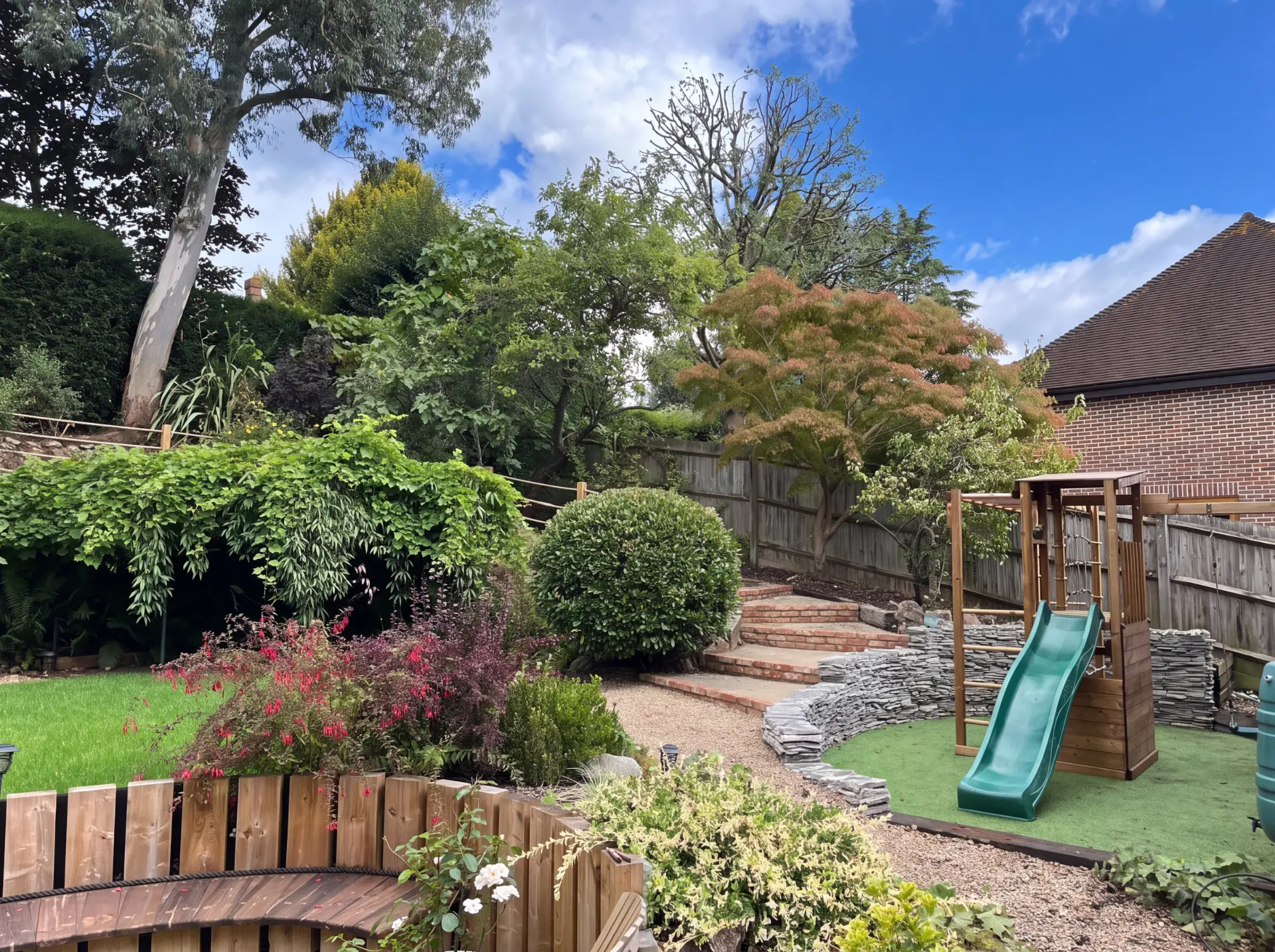 Bespoke landscaping with brick steps, structural dry stone retaining walls and level lawns